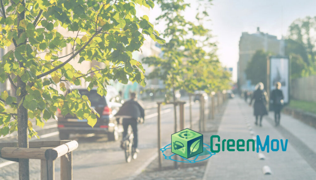 Photo d'une rue bordée d'arbres avec une voiture et un vélo. Deux piétons marchent sur le trottoir. Le logo du projet GreemMov est superposé à l'image.